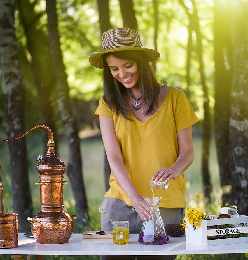 Lady making essential oils with cooper stil
